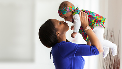 Mother lifting and kissing baby