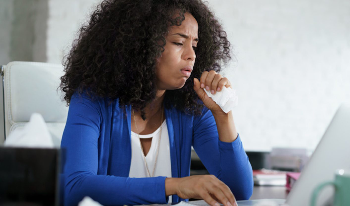 Woman coughing at desk