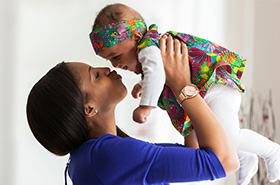 Mother lifting and kissing baby