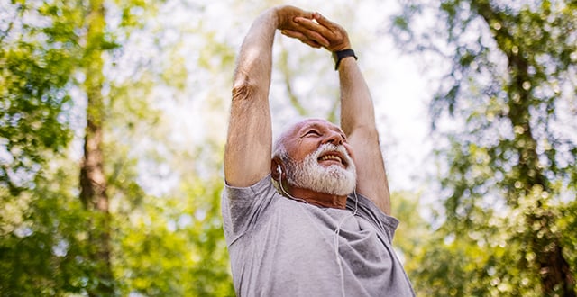 Man stretching under trees